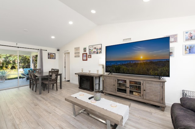 living room with light hardwood / wood-style flooring and vaulted ceiling