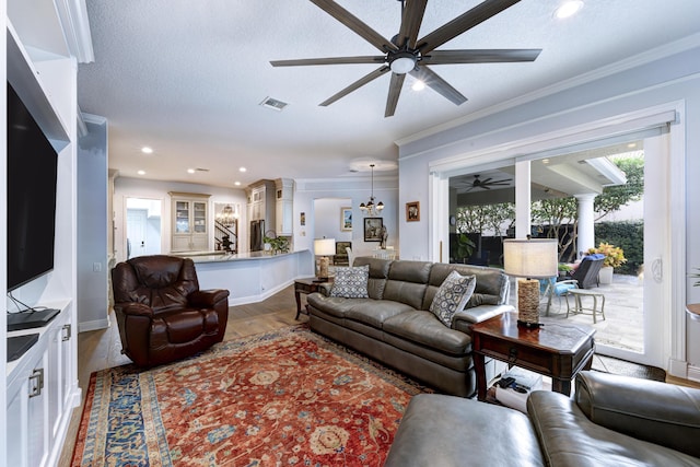 living room featuring crown molding, wood-type flooring, and a textured ceiling