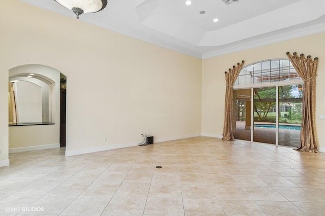 tiled spare room with a tray ceiling and ornamental molding