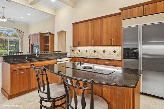 kitchen featuring stainless steel built in refrigerator, sink, a kitchen island, a kitchen bar, and kitchen peninsula