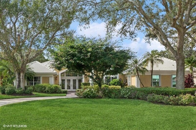 view of front of home with a front lawn and french doors