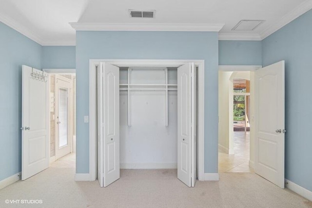 unfurnished bedroom with crown molding, a closet, and light colored carpet