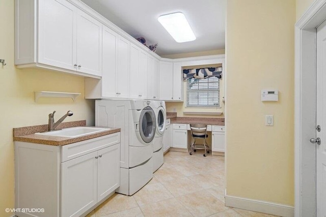 laundry area featuring cabinets, light tile patterned flooring, washing machine and clothes dryer, and sink