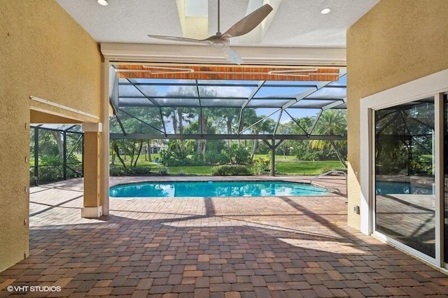 view of swimming pool featuring a lanai, ceiling fan, and a patio