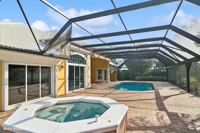 view of swimming pool with an in ground hot tub, a patio, and a lanai