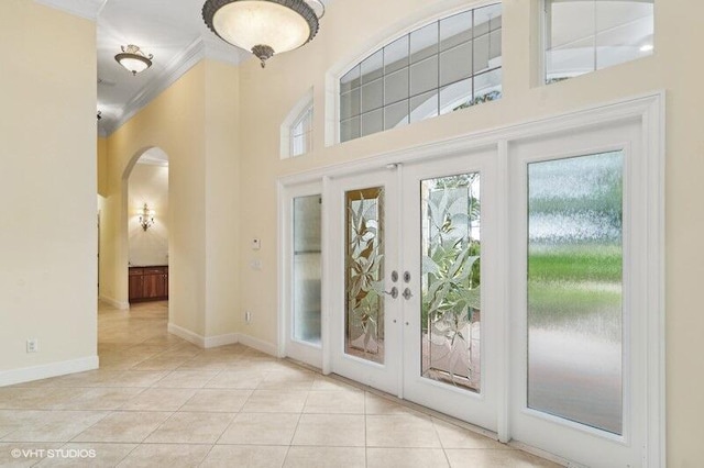 doorway to outside featuring french doors, light tile patterned floors, and ornamental molding