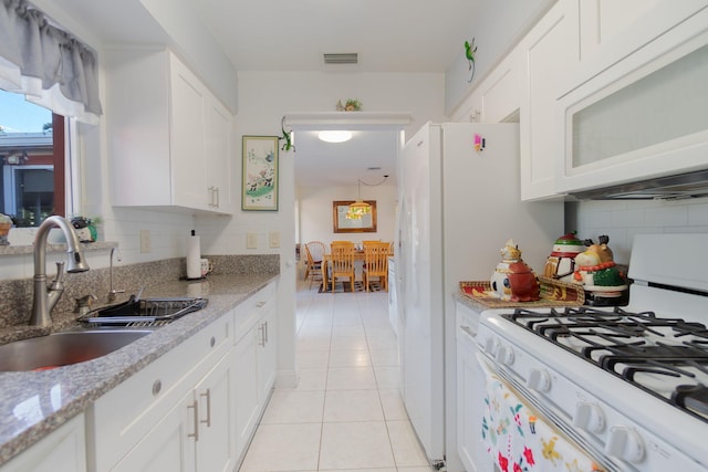 kitchen featuring backsplash, white appliances, sink, light tile patterned floors, and white cabinets