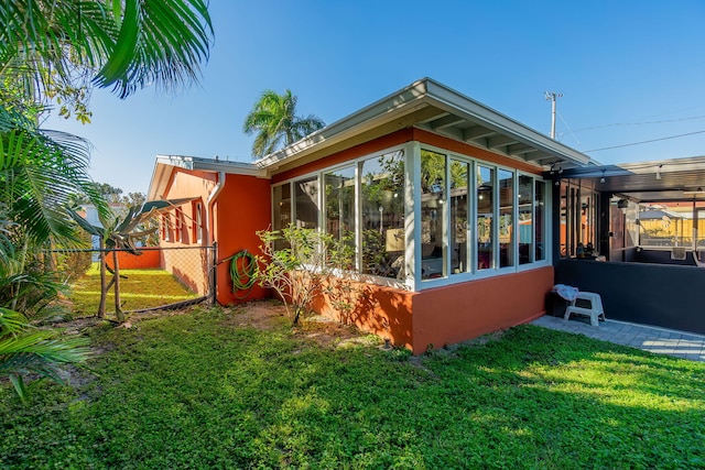 view of side of home featuring a yard and a sunroom