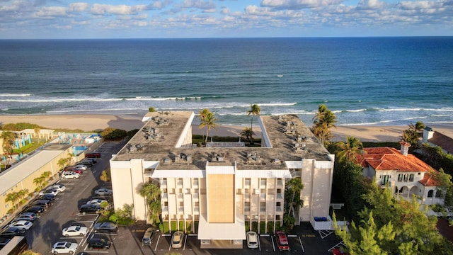 birds eye view of property with a water view and a beach view