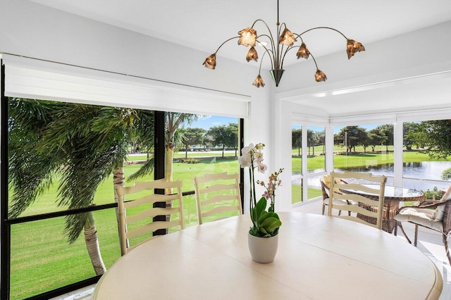 sunroom / solarium featuring a water view and an inviting chandelier