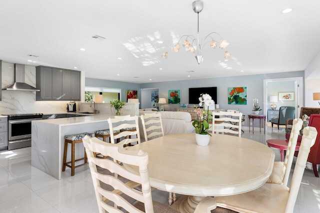 dining area featuring light tile patterned floors, sink, and an inviting chandelier