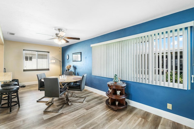 dining space with hardwood / wood-style floors and ceiling fan