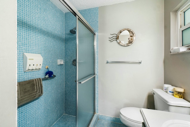 bathroom with tile patterned floors, vanity, toilet, and a shower with door