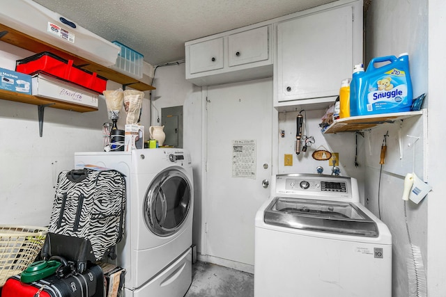 washroom featuring a textured ceiling, electric panel, and washing machine and clothes dryer