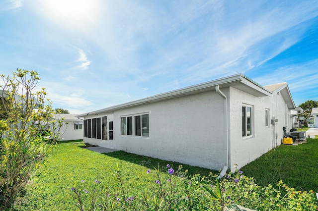 rear view of property featuring a yard and central AC