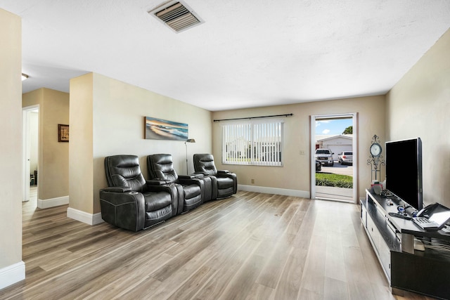 living room featuring light wood-type flooring and a textured ceiling