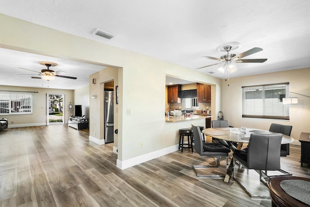 dining area with a wealth of natural light, ceiling fan, and dark hardwood / wood-style floors