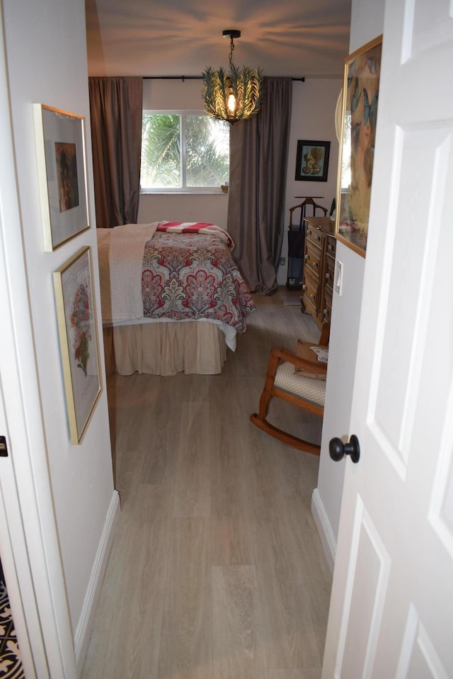 bedroom featuring light hardwood / wood-style floors and a notable chandelier