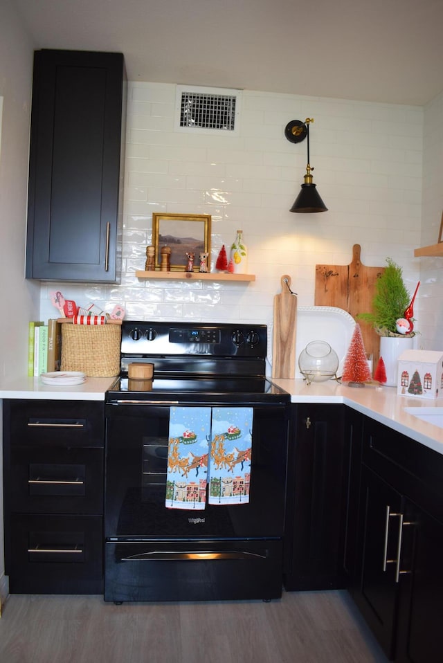 kitchen featuring decorative backsplash, black range with electric stovetop, and light hardwood / wood-style flooring