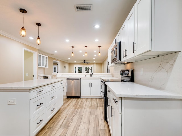 kitchen with pendant lighting, white cabinetry, kitchen peninsula, stainless steel appliances, and light stone countertops