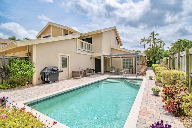 rear view of property featuring a balcony and a patio area