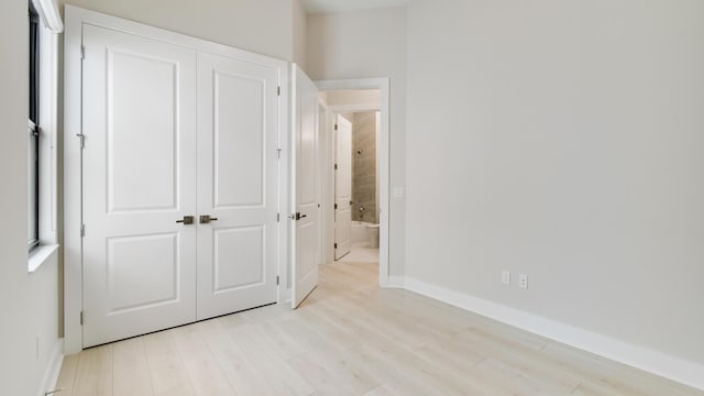 unfurnished bedroom with light hardwood / wood-style floors and a closet