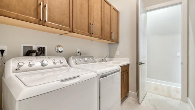 washroom featuring cabinets, separate washer and dryer, and sink