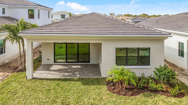 back of property with a patio and a lawn