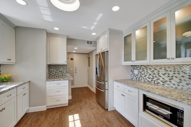 kitchen featuring white cabinetry, stainless steel refrigerator with ice dispenser, light stone countertops, and light hardwood / wood-style floors