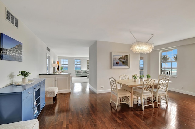 dining area with dark hardwood / wood-style floors and a chandelier