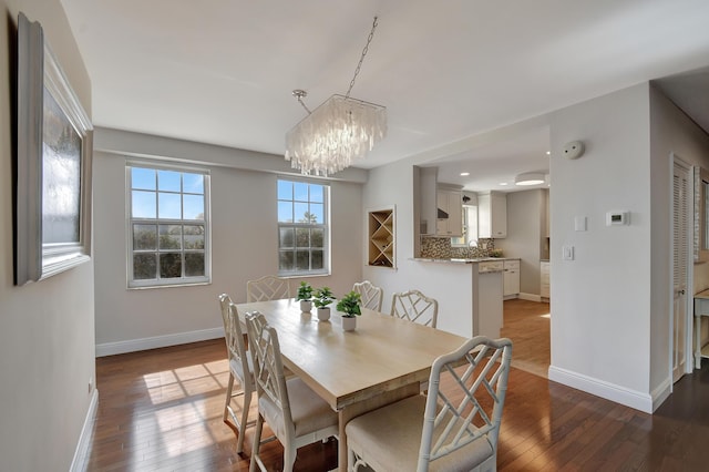 dining room with wood-type flooring and a notable chandelier