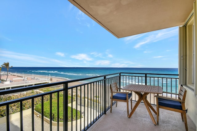 balcony featuring a view of the beach and a water view