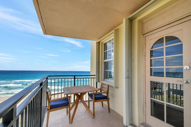 balcony featuring a water view and a view of the beach