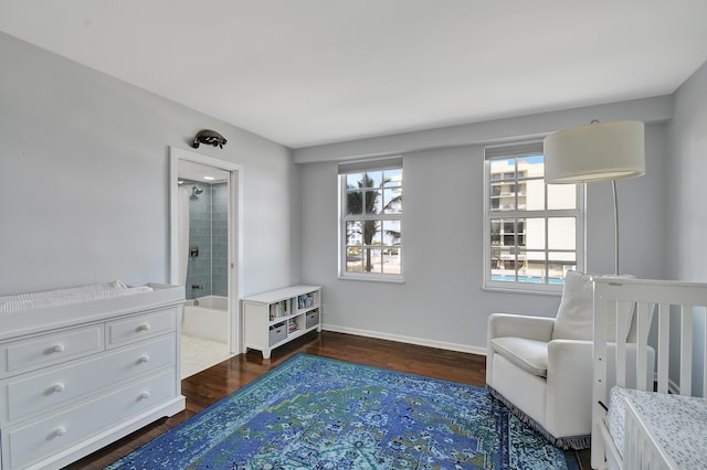 bedroom featuring ensuite bath and dark hardwood / wood-style flooring