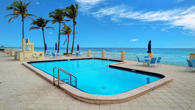 view of pool featuring a water view and a patio area