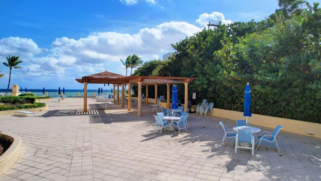 view of patio / terrace with a pergola and a water view