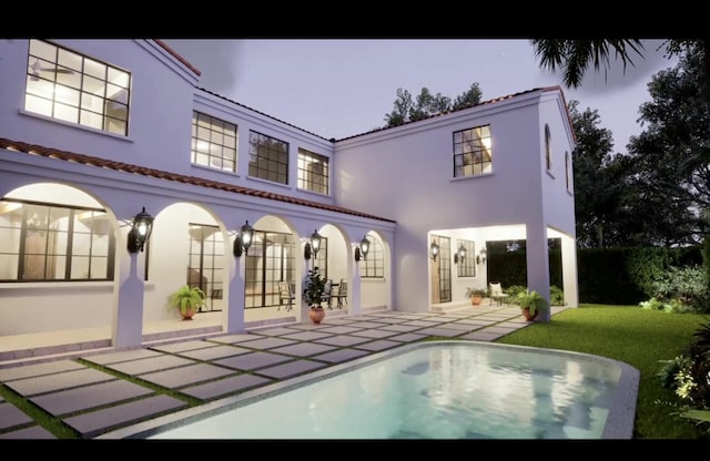 rear view of property with a lawn and a patio area