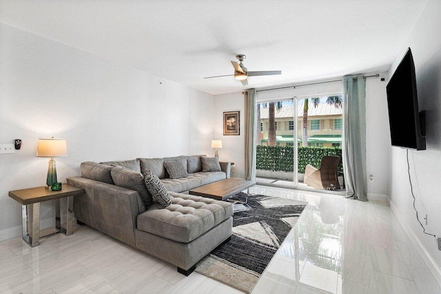 living area with ceiling fan and baseboards