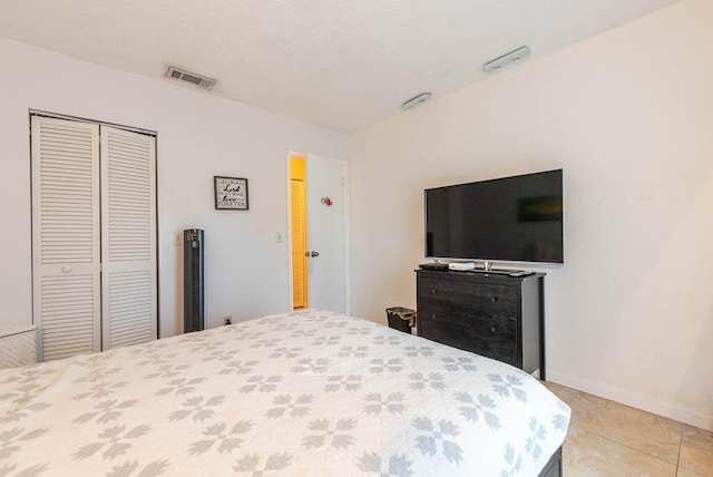 tiled bedroom featuring a textured ceiling