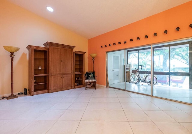 unfurnished living room featuring vaulted ceiling and light tile patterned flooring