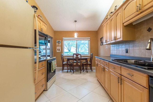 kitchen featuring sink, hanging light fixtures, tasteful backsplash, light tile patterned floors, and black appliances