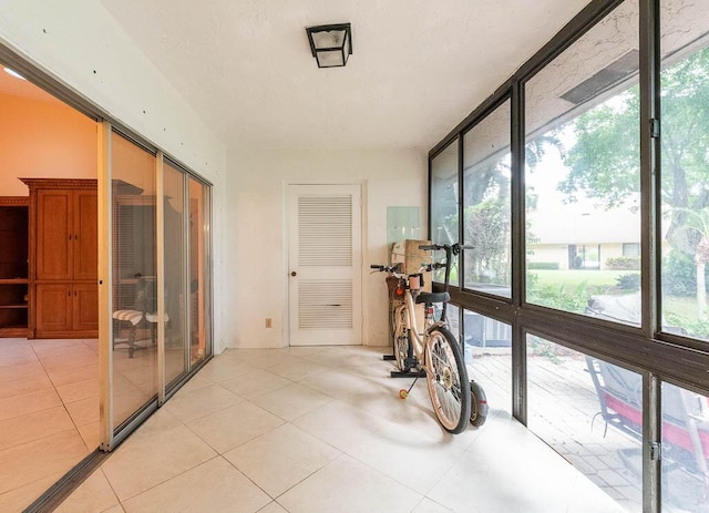 corridor with light tile patterned floors and a wealth of natural light