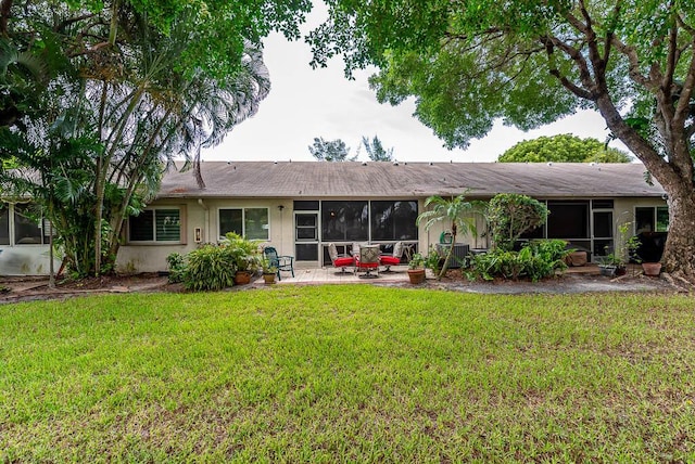 back of property with a patio area and a yard