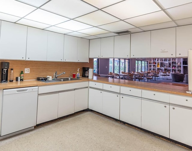 kitchen with dishwasher, white cabinets, a drop ceiling, and sink