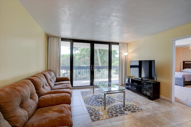 living room featuring ceiling fan, floor to ceiling windows, and a textured ceiling