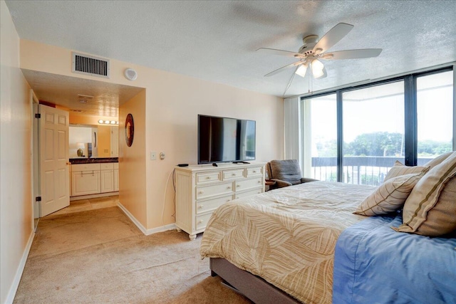 carpeted bedroom featuring access to exterior, ceiling fan, expansive windows, and a textured ceiling