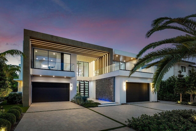 contemporary home featuring a garage and a balcony