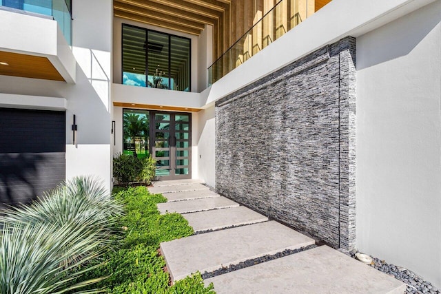 view of exterior entry featuring french doors and stucco siding