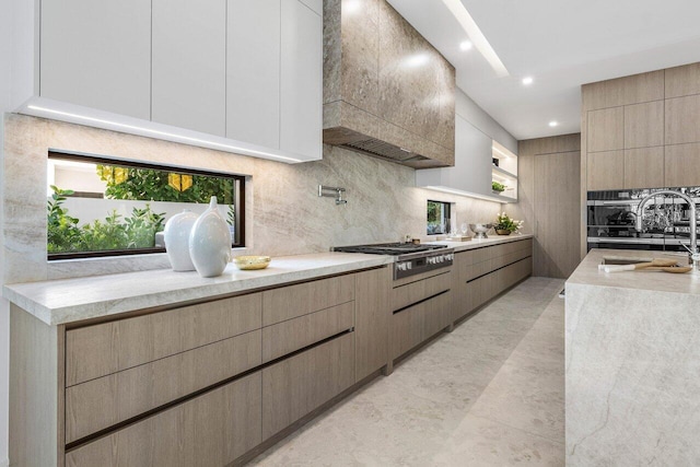 kitchen featuring stainless steel gas cooktop, a sink, custom exhaust hood, backsplash, and modern cabinets