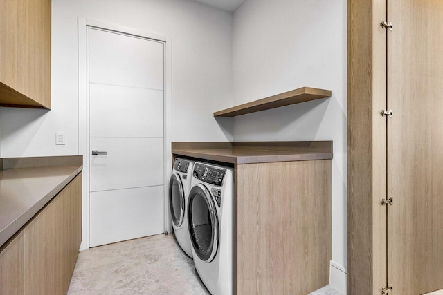 laundry area with cabinet space and independent washer and dryer